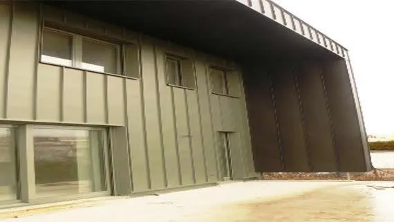 Bardage façade en zinc pigmento vert et habillage sous face et latéral en zinc prépatiné en joint debout.